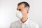 Man in anti epidemic respirator in white shirt on white