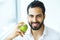 Man With Apple. Beautiful male With White Smile, Healthy Teeth.