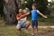 Man applying insect repellent on son`s arm in park. Tick bites prevention