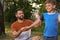 Man applying insect repellent on son`s arm in park. Tick bites prevention