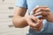 Man applying ointment from tube onto his wrist indoors, closeup