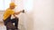 Man applying wallpaper glue using a brush.