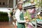 Man in apron arranging potted orchids on rack