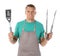 Man in apron with barbecue utensils on white