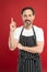 Man in apron. Confident mature handsome man in apron red background. He might be baker gardener chef or cleaner. Good in