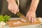 A man in a apron is cutting a chicken. Preparation of ingredients.