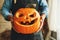 Man in apron with Halloween pumpkin monster spooky jack-o-lantern in hands