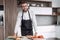 Man in an apron slicing salami for sandwiches