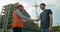 Man architects engineers and male client shaking hands at construction site. Professions, construction, workers