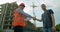 Man architects engineers and male client shaking hands at construction site. Professions, construction, workers
