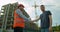 Man architects engineers and male client shaking hands at construction site. Professions, construction, workers