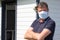 Man arms crossed wearing disposable fabric cotton homemade mask outdoors against coronavirus covid-19 dangerous virus