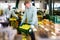 Man arranges crates with harvest of apples at apples factory