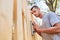 Man as a handyman grinding at the fence in the garden