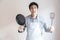 Man asian cooking in kitchen of home He holds bowl and  spatula  to great hand on microwave in kitchen service lifestyle family