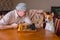 Man asking basenji dog to make next move in a chess family tournament