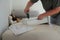 A man assembling a drawer of a computer desk for his son using power cordless screwdriver. He is using a tool and instructions to