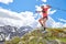 Man athlete jumps between the stones during a trail workout in the mountains