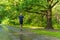 A man athlete runs in the park outdoors, around the forest, oak trees green grass young enduring athletic athlete active