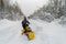 A man, an athlete in a warm sports suit rides a snowmobile