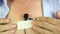 A man attaches a hidden microphone to his chest with an adhesive tape.