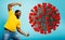 Man attacks with a punch the coronavirus. Blue background