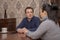 A man attentively listens to a woman sitting at a Desk in the office. Concept, psychological help, problem solving training, famil