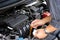 Man or auto mechanic worker hands checking the car engine oil and maintenance before traveling for safety