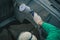 Man with automotive air spray gun in action during the restoration of a vintage car. Applying first base layer of paint onto bare