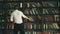 Man on background of bookshelves. He take book and read. University people 4k.