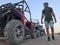 The man on the background of a sports car is buggy. ATV desert tour in Egypt. Outdoor activities and adventures in the stone