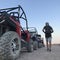 The man on the background of a sports car is buggy. ATV desert tour in Egypt. Outdoor activities and adventures in the stone