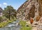 Man with backpack hiking along river in Fann mountain, Tajikistan