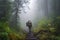 man, with backpack and hiking gear, taking the first steps into misty forest