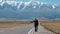 Man with Backpack Hitchhiking on a Mountain Road