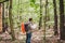 Man with Backpack and map searching directions in wilderness area. Tourist with backpack using map in forest. concept