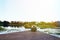 Man with backpack sitting alone on the edge of pond pondering an