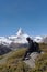 A man with backpack sitting on rock with Matterhorn mountain view in Switzerland