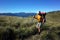 Man with backpack solo hiking on grassy highland mountain landscape in Puyehue National Park, Los Lagos Region