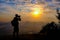 Man backpacker with her dslr camera silhouette sunset background