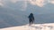 Man backpacker hiking snowy mountain hillside on cold winter day.