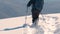 Man backpacker hiking snowy mountain hillside on cold winter day