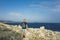 Man with bag on back standing on rocky coast line in Croatia close sea