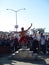 Man balancing on a board on a roller pin in front of crowd of to