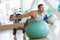 Man Balancing On Swiss Ball At Gym