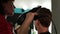 A man at barber`s. Female hairdresser drying the men`s head using by hairdryer.