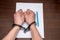 A man with bare hands in handcuffs sits at a table in front of a blank sheet of paper and a fountain pen. 4