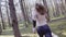 A man with a bare torso, long hair and a knife in his hands running through the woods. Shooting from the back in motion. Slow mo.