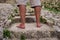A man with barefoot tanned legs walks on a stone staircase