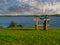 Man in baseball hat sitting on a wooden bench looking at lake Corrib and beautiful cloudy sky. Concept relaxation, meditation